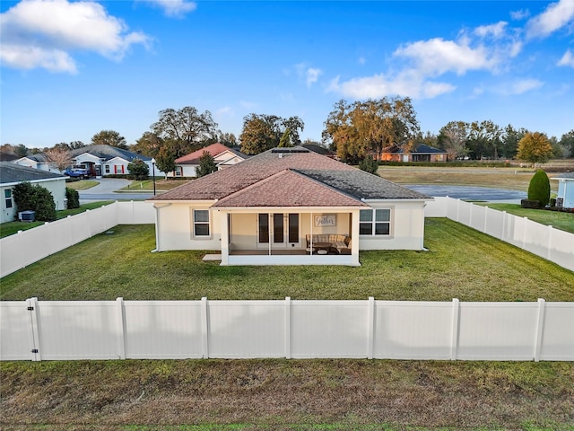 rear view of property with a lawn