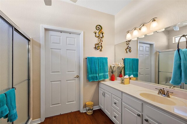 bathroom featuring hardwood / wood-style floors, vanity, and a shower with door