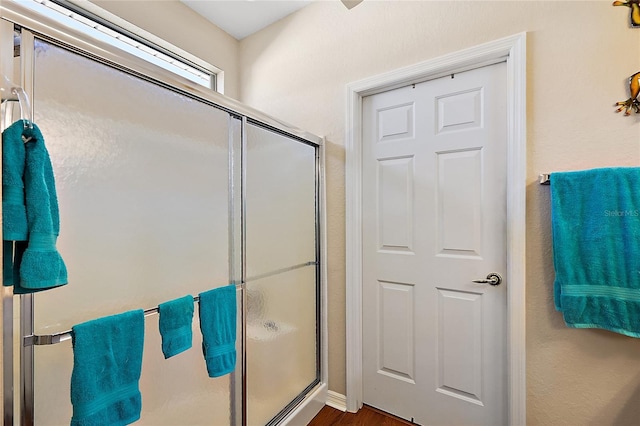 bathroom featuring hardwood / wood-style flooring and walk in shower