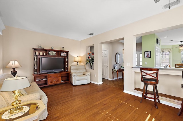 living room featuring ceiling fan and dark hardwood / wood-style floors