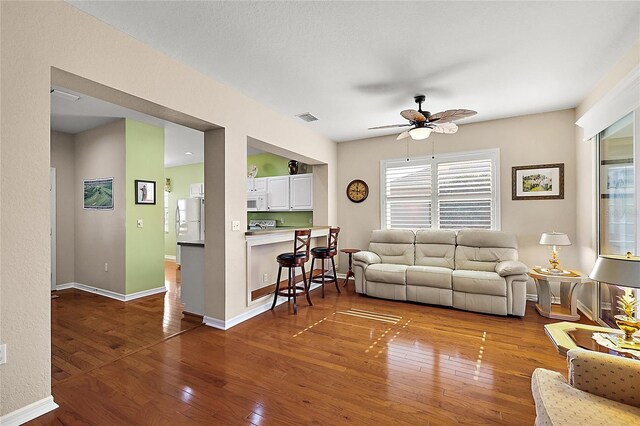 living room featuring ceiling fan and wood-type flooring