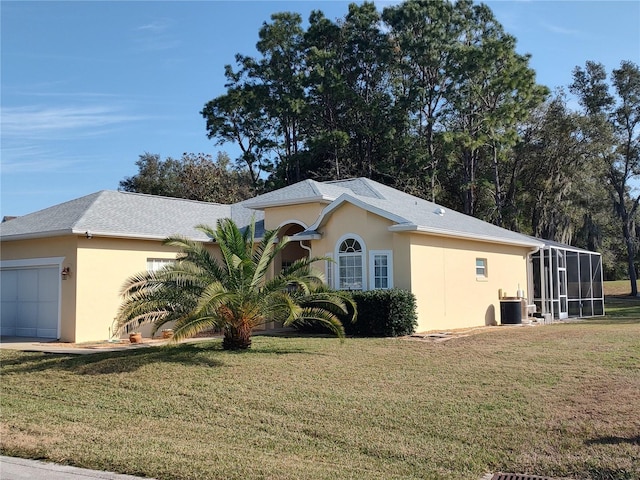 ranch-style home with cooling unit, a garage, and a front lawn