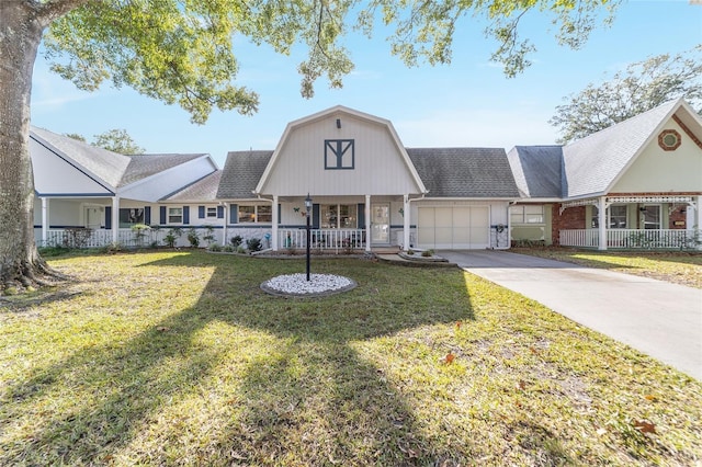 view of front of house with covered porch, a garage, and a front lawn