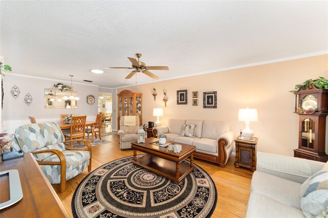 living room featuring crown molding, ceiling fan, and light hardwood / wood-style floors