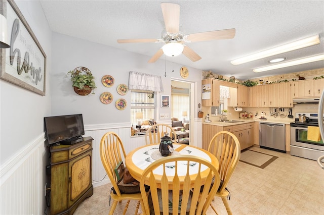 dining room with a textured ceiling, ceiling fan, and sink