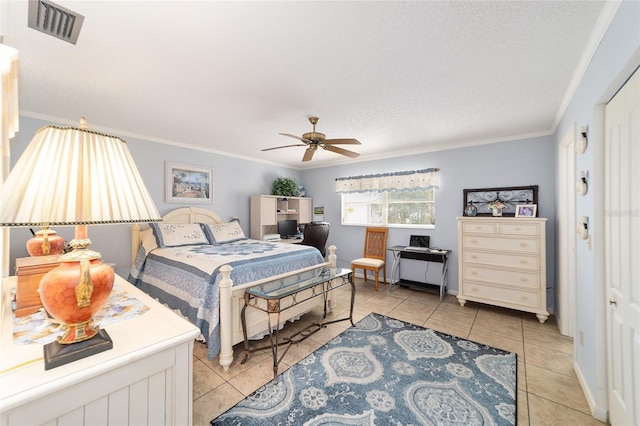 tiled bedroom with a textured ceiling, ceiling fan, and crown molding