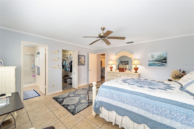 bedroom featuring a walk in closet, a closet, ceiling fan, and ornamental molding