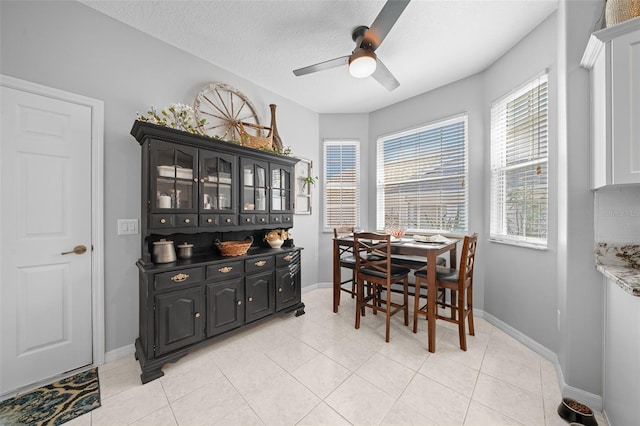 dining space with ceiling fan, light tile patterned floors, and a textured ceiling