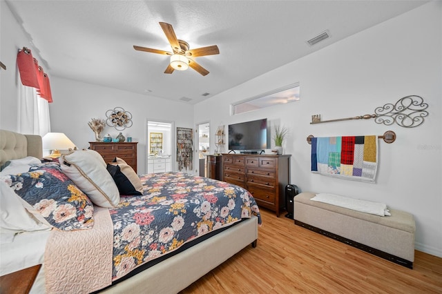 bedroom with ceiling fan, light wood-type flooring, and a textured ceiling