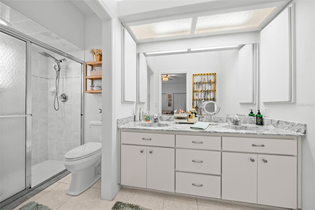 bathroom featuring ceiling fan, walk in shower, tile patterned flooring, toilet, and vanity