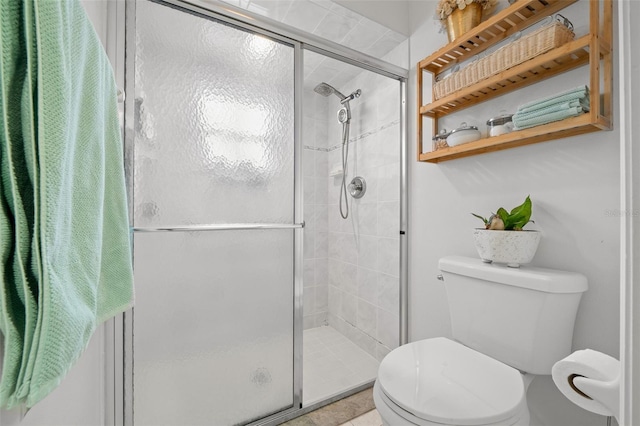 bathroom with tile patterned floors, toilet, and an enclosed shower