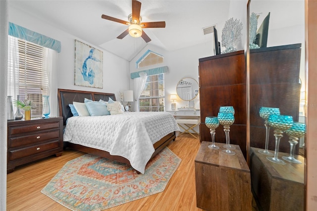 bedroom with ceiling fan, vaulted ceiling, and light wood-type flooring