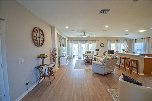 living room featuring light hardwood / wood-style flooring and ceiling fan