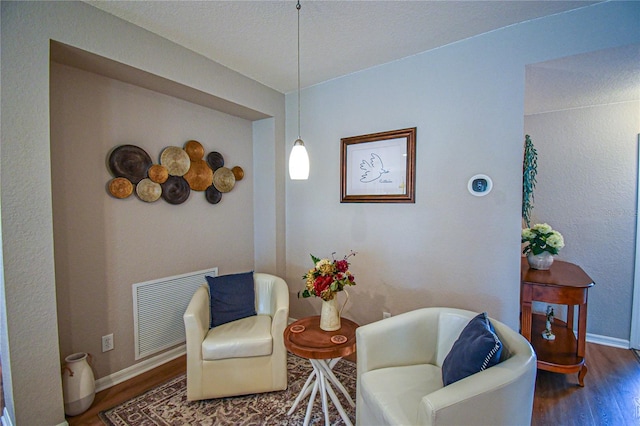 sitting room with dark wood-type flooring