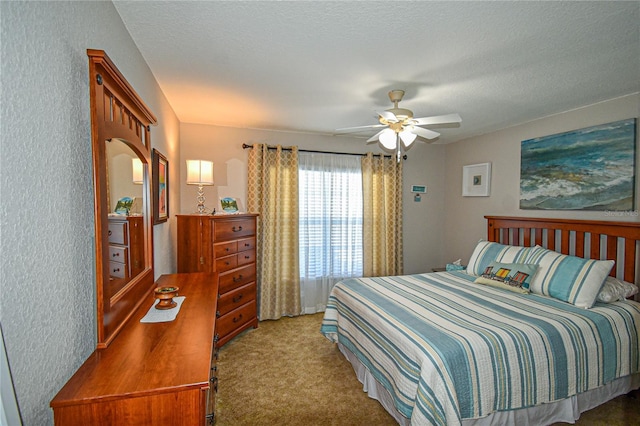 bedroom featuring a textured ceiling, light colored carpet, and ceiling fan