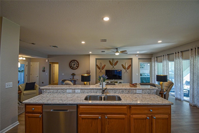 kitchen featuring dishwasher, an island with sink, dark hardwood / wood-style floors, and sink