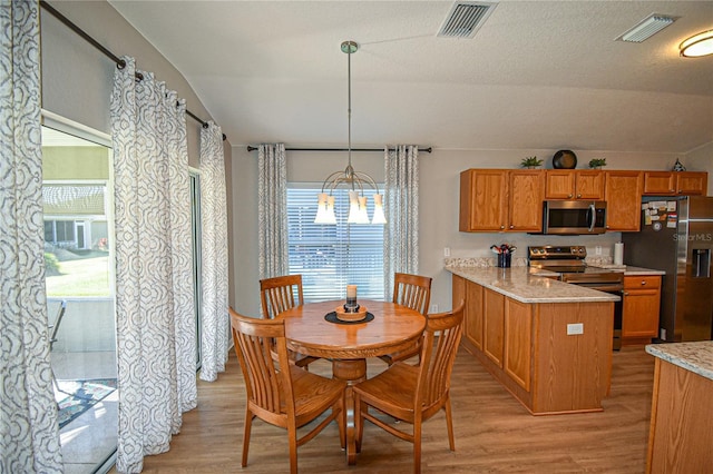 dining space featuring light hardwood / wood-style flooring and a chandelier