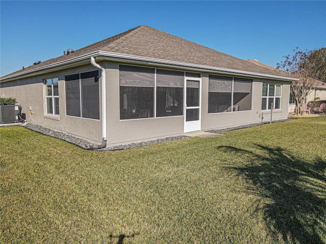 rear view of property featuring a yard and cooling unit