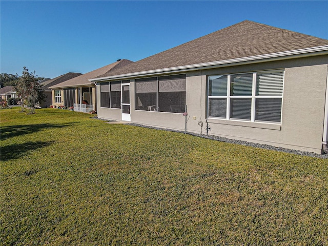 back of property featuring a sunroom and a yard