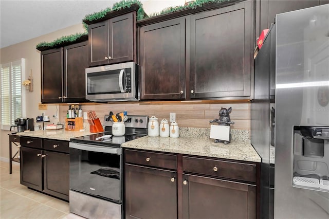 kitchen featuring backsplash, light tile patterned floors, dark brown cabinets, and appliances with stainless steel finishes