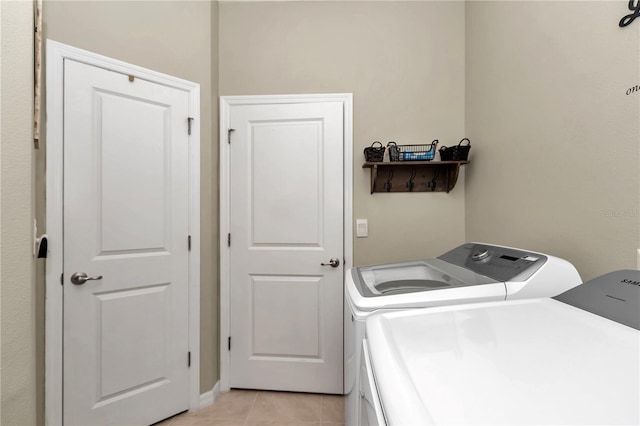 laundry room with light tile patterned flooring and washing machine and clothes dryer