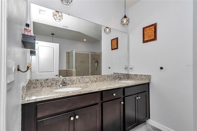 bathroom featuring a shower with door and vanity