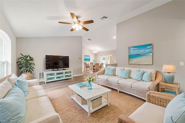 living room featuring hardwood / wood-style flooring, ceiling fan, and vaulted ceiling