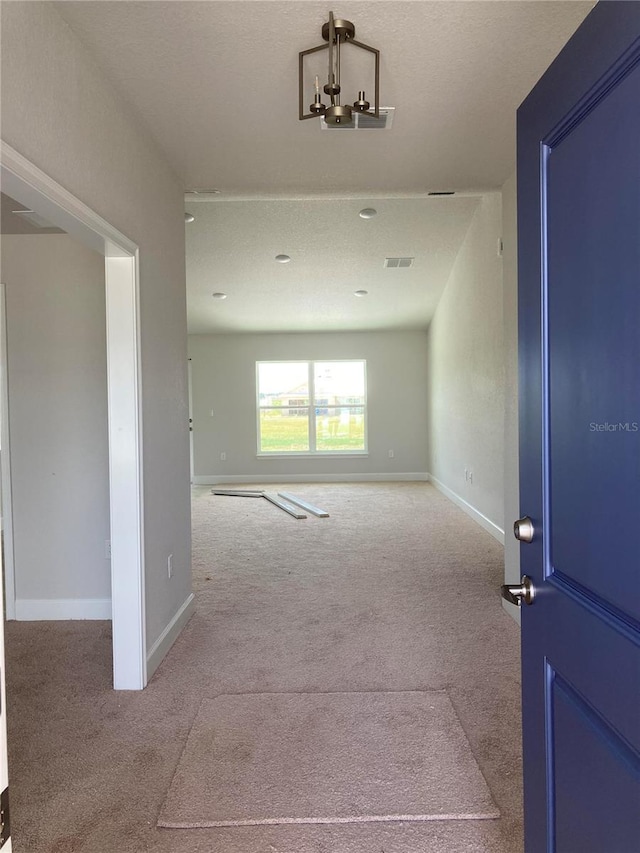 interior space featuring light colored carpet and a notable chandelier