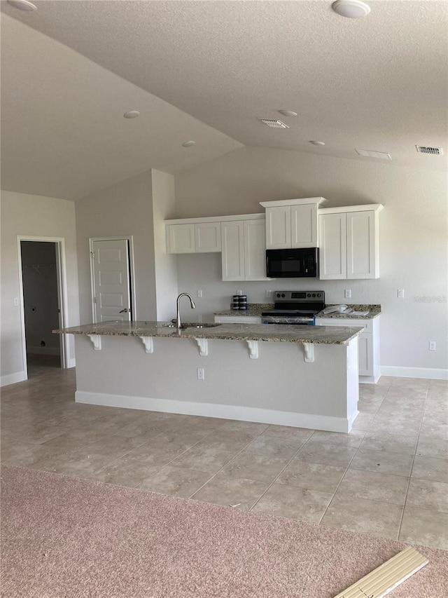 kitchen featuring sink, white cabinetry, stainless steel range with electric cooktop, and an island with sink