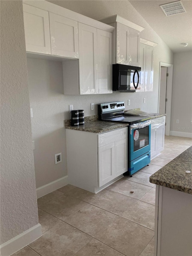 kitchen with white cabinetry, stainless steel electric range oven, and dark stone counters