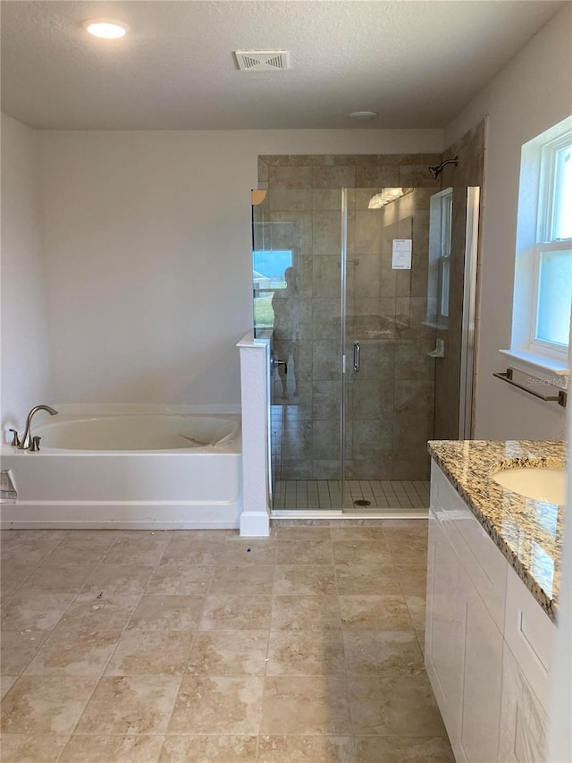 bathroom with vanity, a textured ceiling, and shower with separate bathtub