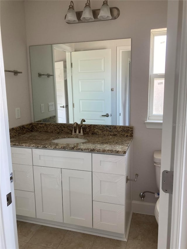 bathroom featuring tile patterned floors, vanity, and toilet