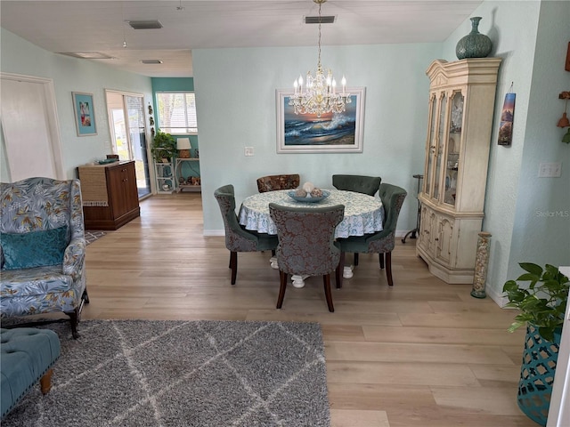 dining room with a chandelier and light hardwood / wood-style flooring