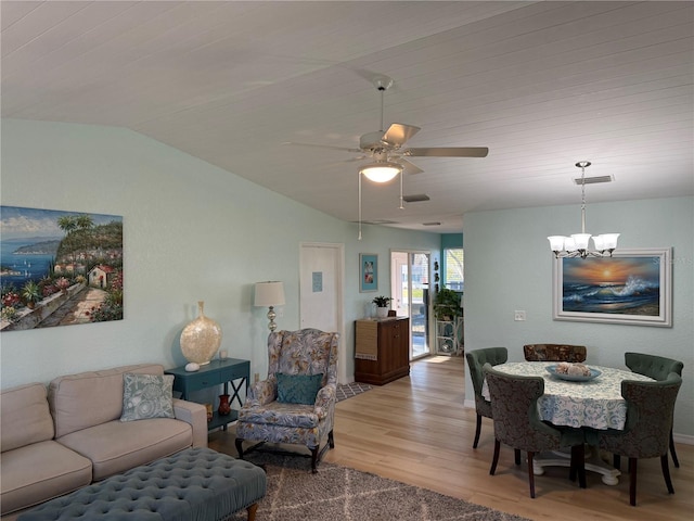 living room featuring lofted ceiling, wood-type flooring, and ceiling fan with notable chandelier