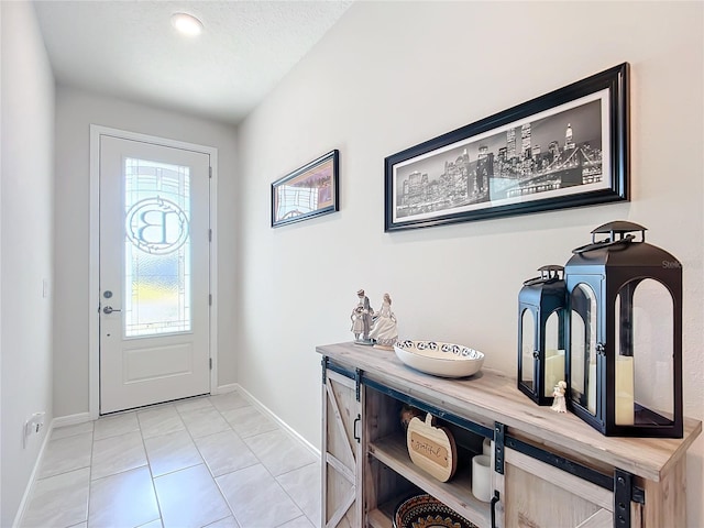 tiled entryway with a textured ceiling