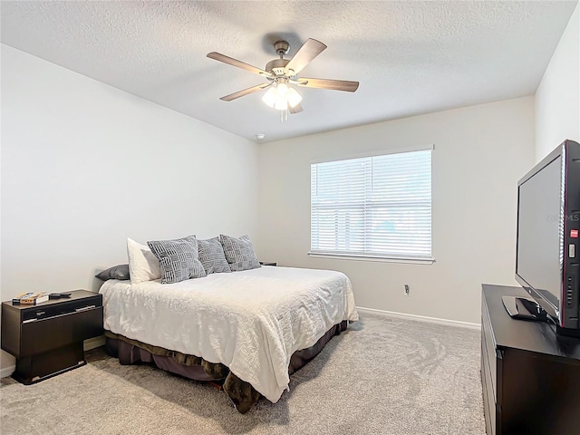 carpeted bedroom with a textured ceiling and ceiling fan