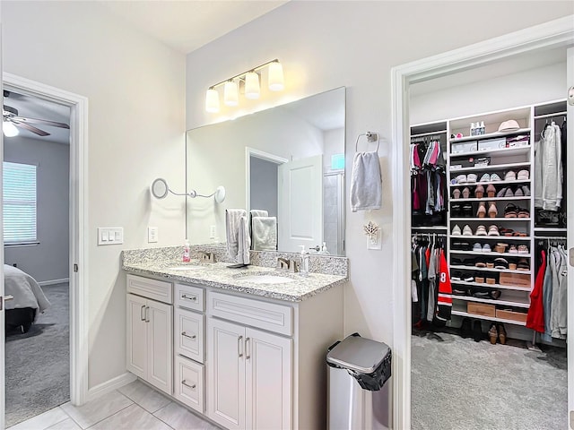 bathroom with tile patterned flooring, vanity, and ceiling fan