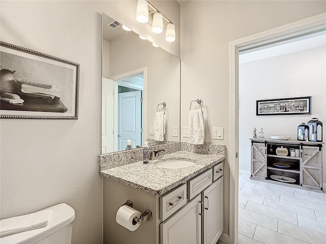 bathroom with tile patterned flooring, vanity, and toilet