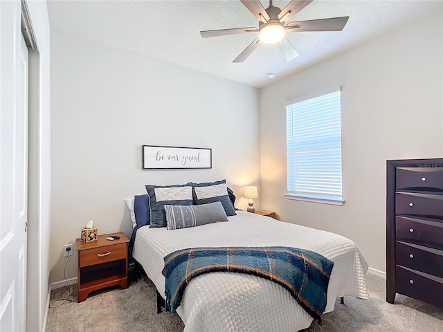 carpeted bedroom featuring ceiling fan and a closet