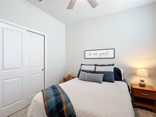 carpeted bedroom featuring ceiling fan and a closet