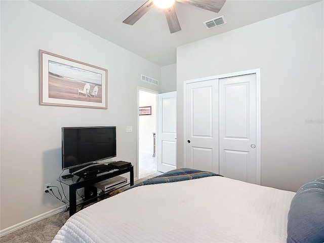 bedroom with ceiling fan, light carpet, and a closet