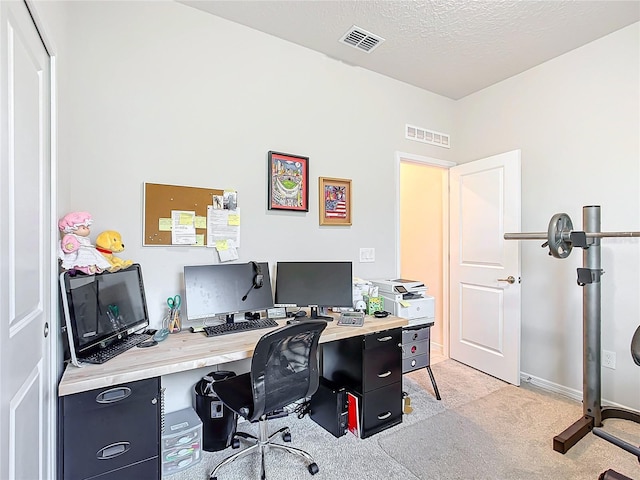 carpeted office featuring a textured ceiling