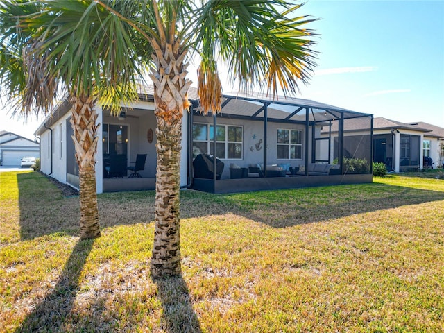 rear view of property with glass enclosure and a lawn