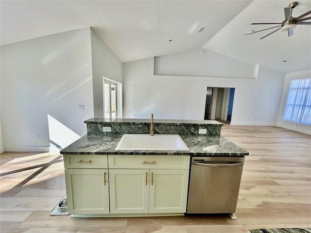 kitchen with sink, light hardwood / wood-style flooring, dark stone countertops, stainless steel dishwasher, and ceiling fan