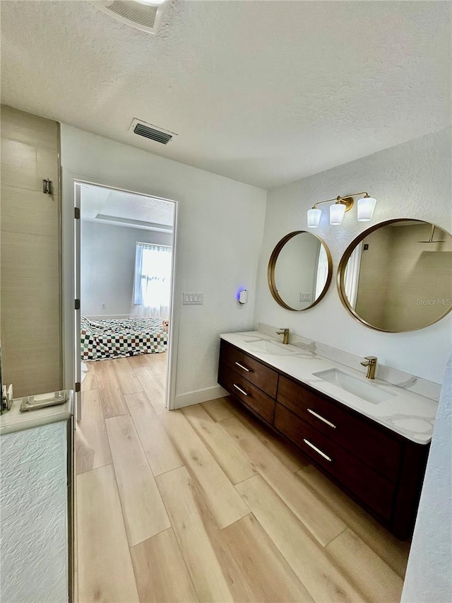 bathroom featuring vanity, hardwood / wood-style floors, and a textured ceiling