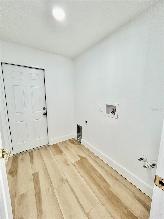 clothes washing area with gas dryer hookup, washer hookup, hardwood / wood-style floors, and electric dryer hookup