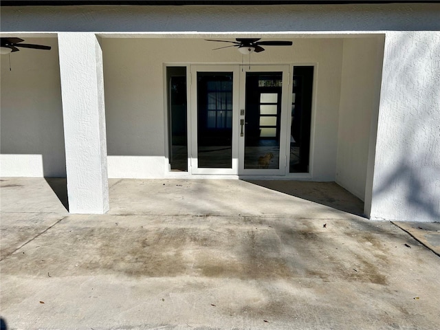 entrance to property with ceiling fan and a patio area