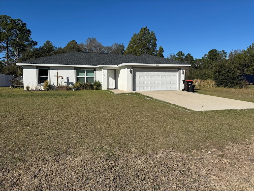 ranch-style house featuring a garage and a front lawn