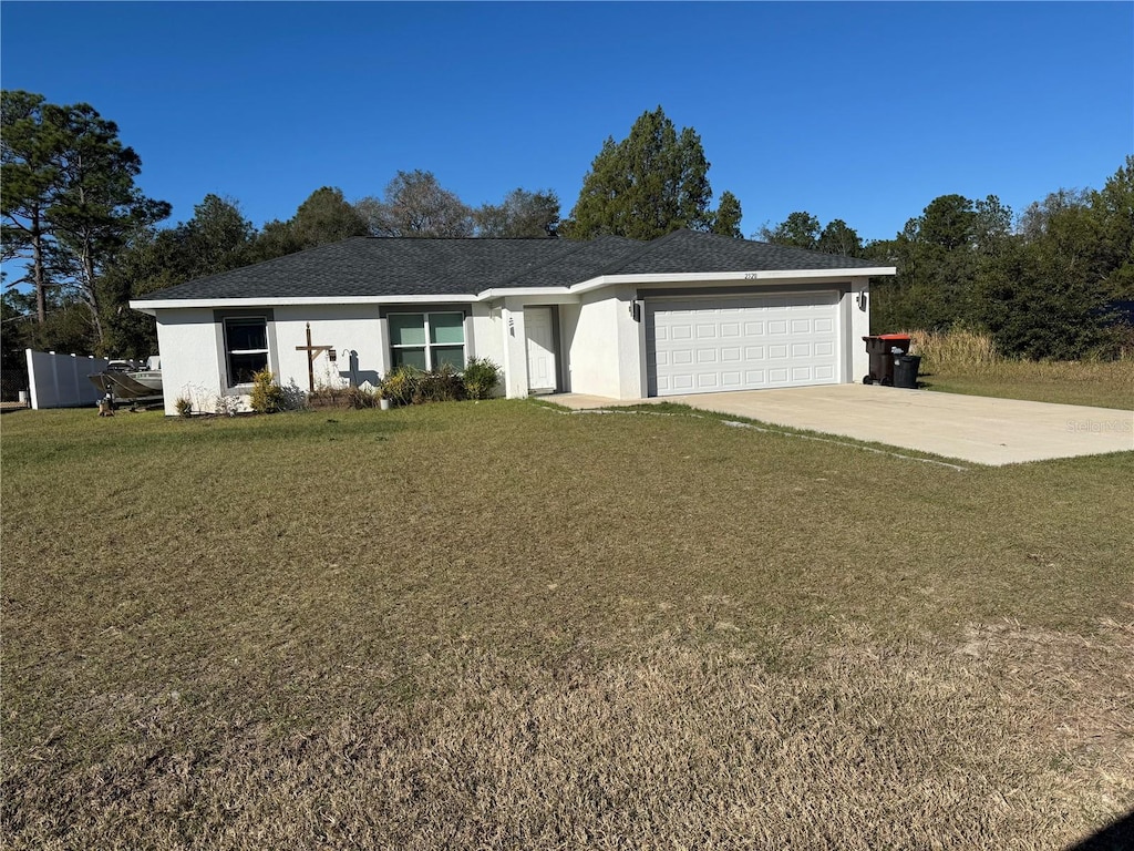 ranch-style house featuring a front lawn and a garage