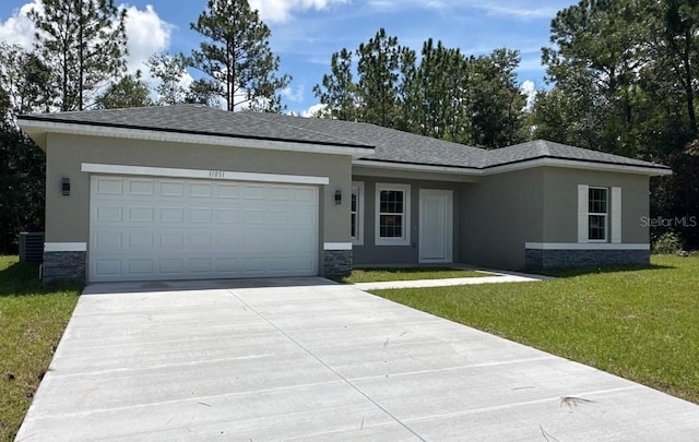 view of front of home with a garage, a front yard, and central air condition unit